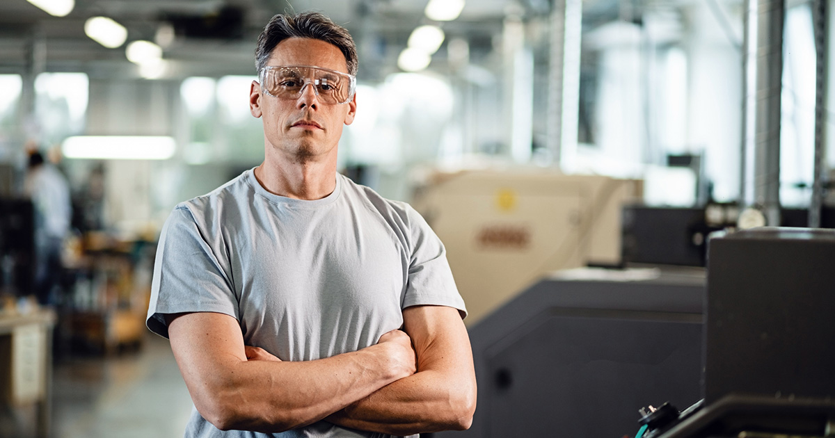 Trabajador con brazos cruzados y gafas de seguridad